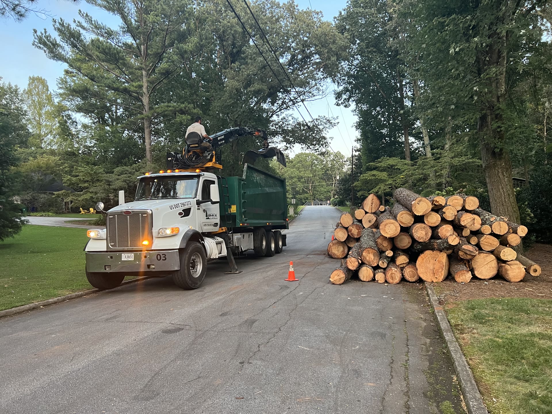Chip truck beside stacked cut logs
